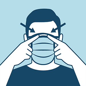 Frontal view of an individual wearing a cloth face covering. Individual is using two fingers to point to either side of the top of the nose, indicating that the covering fits well in this area.